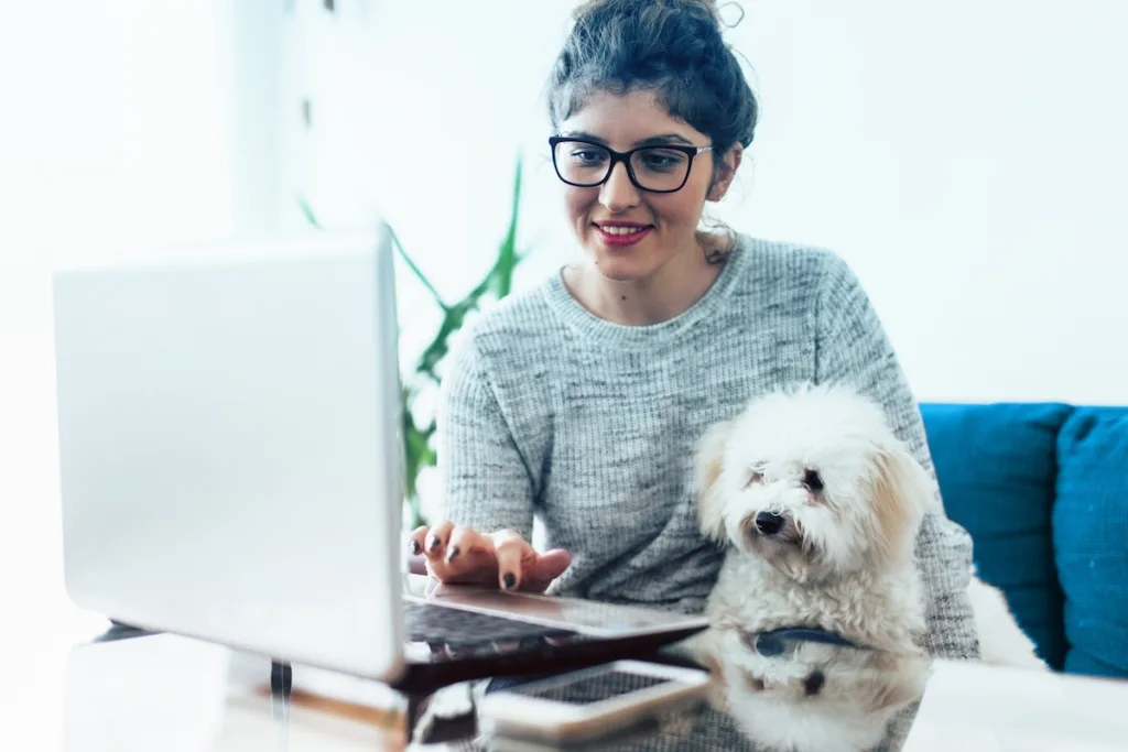 Young woman working at home. She is with her dogs